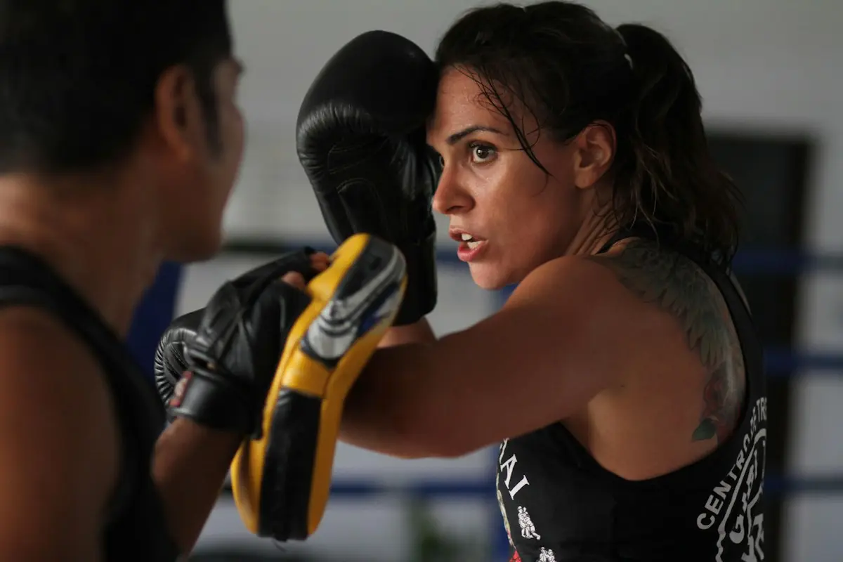 A woman training on the pads with her coach